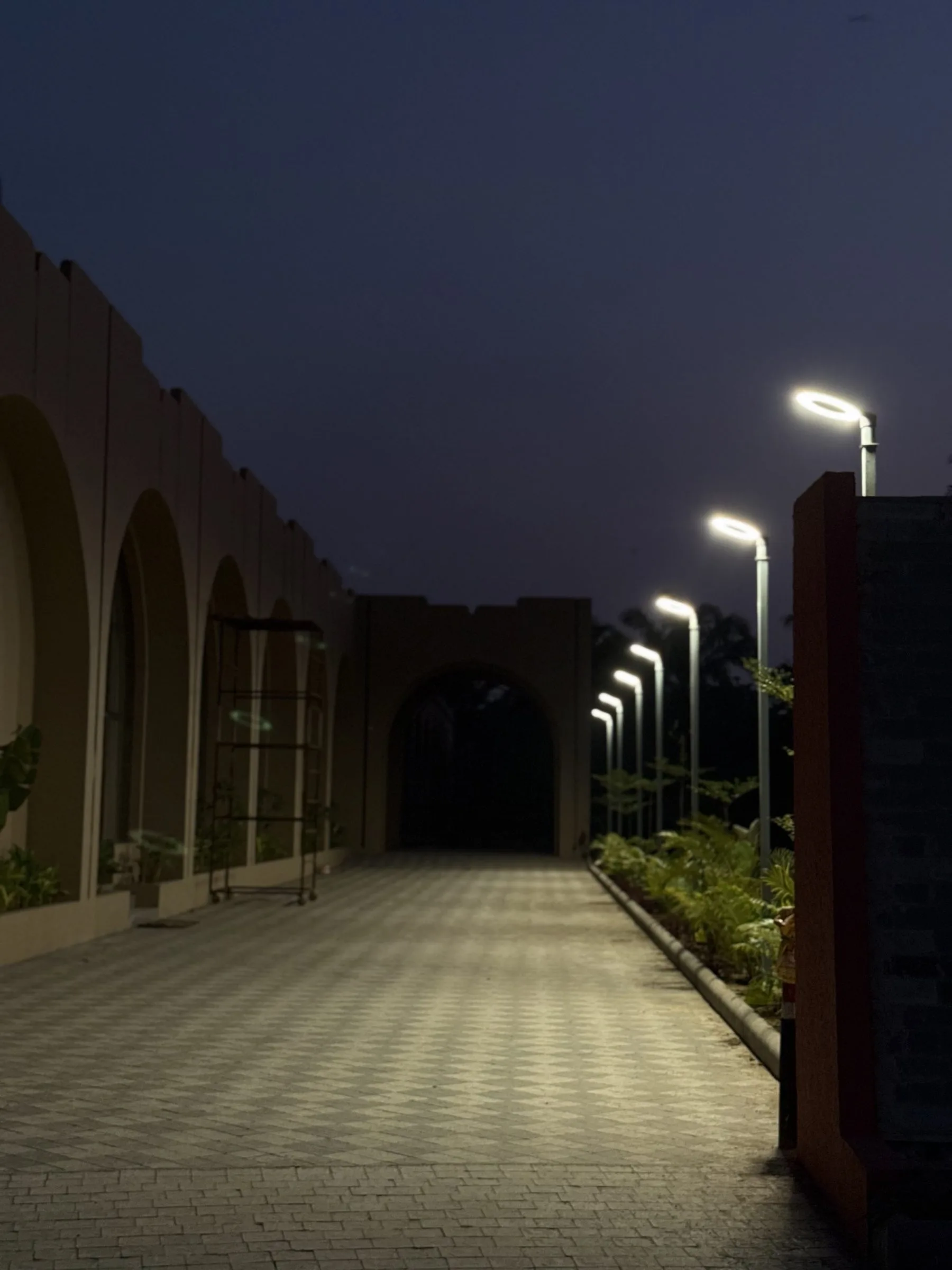 The lit colonnade walkway leading into the property