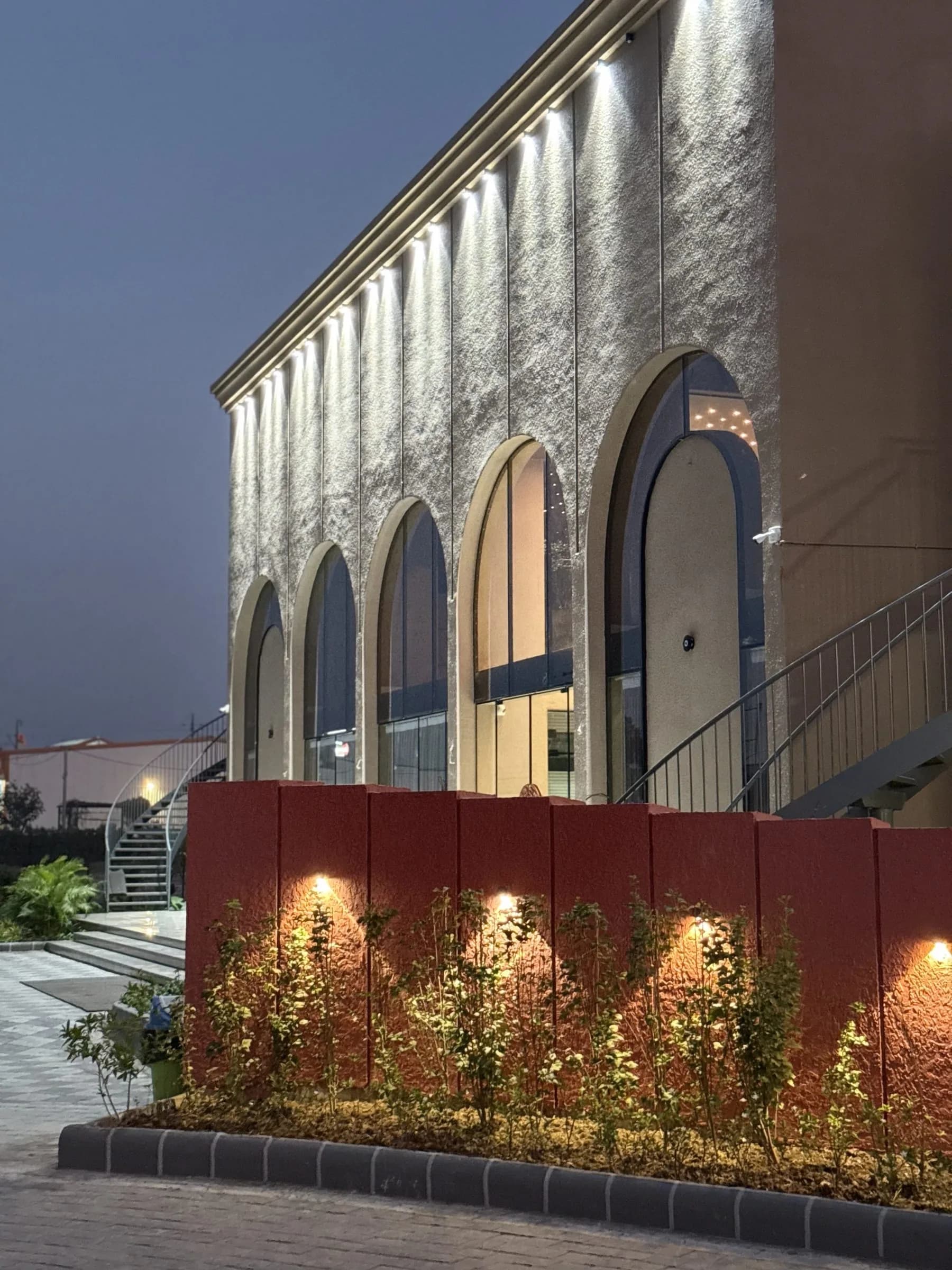 The arched façade uplit at dusk
