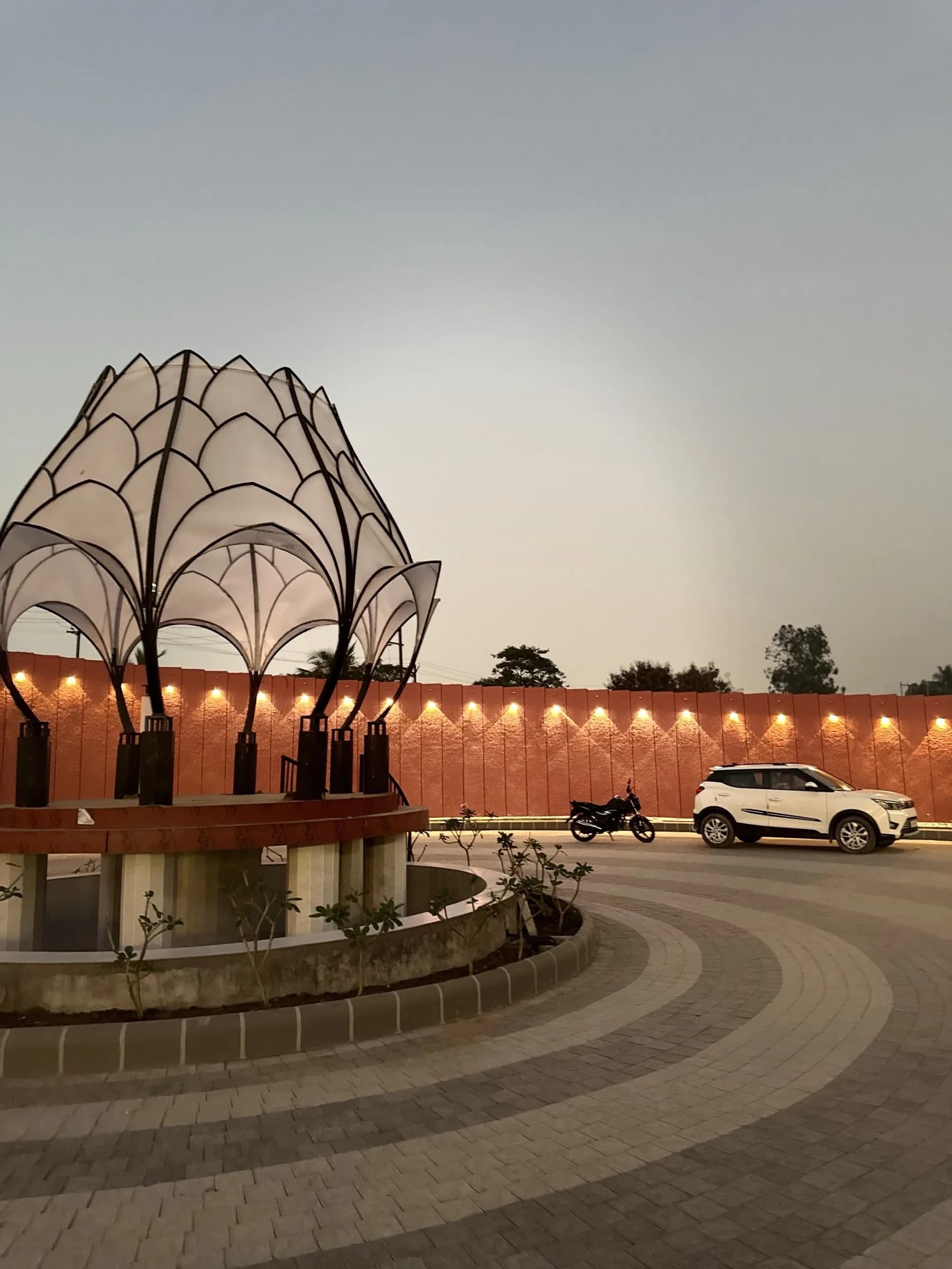 The lotus pavilion centrepiece on the open plot at dusk